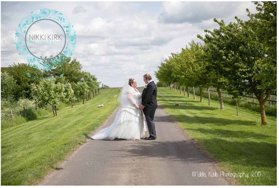 Notley-Tythe-Barn-wedding-photography-Nikki-Kirk-Photography-Cheltenham-bride-and-groom-on-country-road.jpg